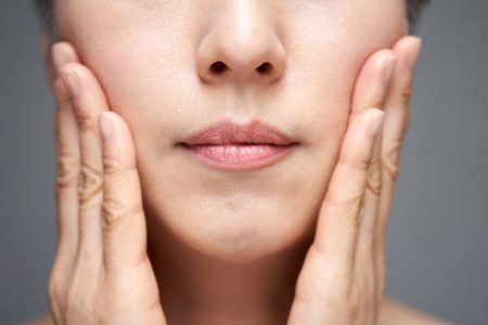 Middle-aged Japanese woman doing cheek massage